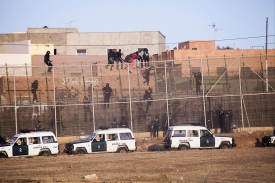La Guardia Civil española sube por la valla para obligar a los migrantes subsaharianos a bajar y devolverlos a Marruecos posteriormente.